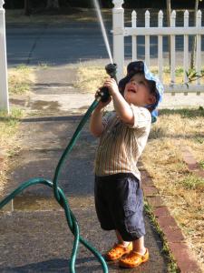 Sylvan “watering” the sky, the sidewalk, and his face.