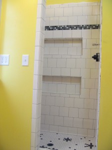 Looking into shower this morning. Note shelves, glass tiles for accent, and funky floor.
