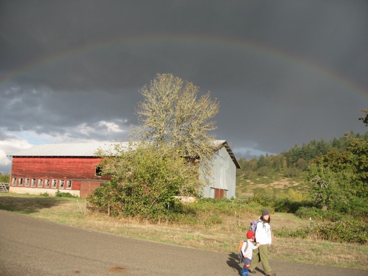 Julie and Sylvan walk in front of a rainbow and the Kienzle barn at Mt. Pisgah, 3 Oct 2009
