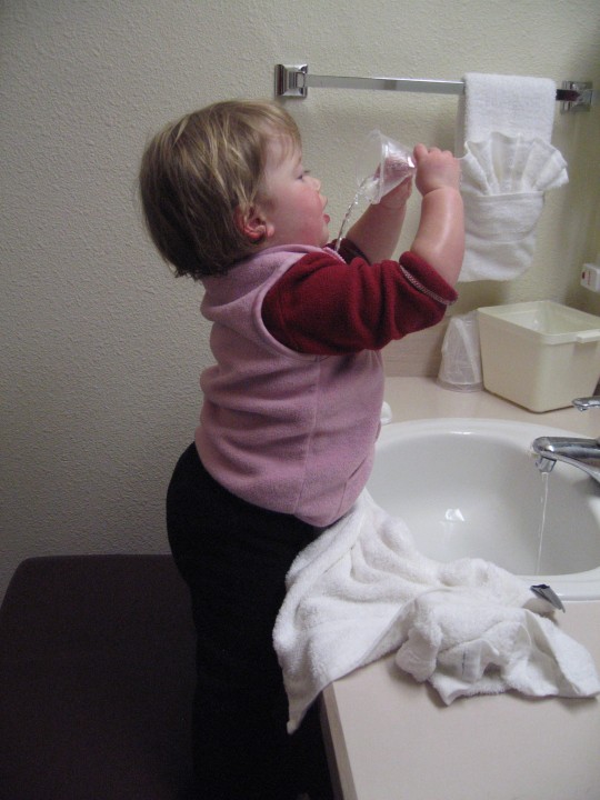 Elena has fun at the sink.